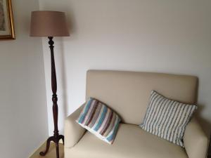 a lamp sitting next to a couch with a pillow at Terraço da Vila in Ponte de Lima