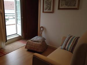a living room with a couch and a chair and a window at Terraço da Vila in Ponte de Lima
