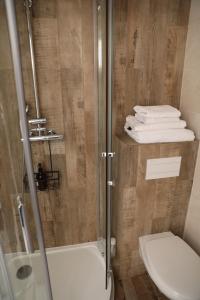 een badkamer met een douche, een toilet en handdoeken bij Eiffel Tour Cosy Oliver in Parijs