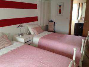 two beds in a room with red and white stripes at Terraço da Vila in Ponte de Lima