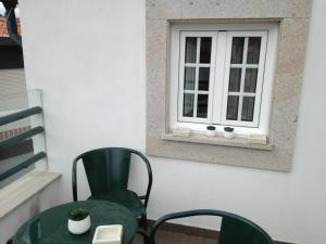 a table and chairs in front of a window at Terraço da Vila in Ponte de Lima