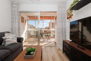 sala de estar con sofá y TV de pantalla plana en Casa Carmen, en Málaga