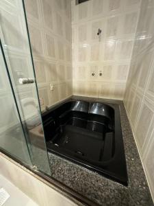 uma cozinha com um lavatório preto no canto em Hotel Estoril Garden & Restaurante em Registro