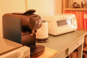 a coffee machine sitting on a counter next to a microwave at B&B Zee-en-Zo Noordwijk in Noordwijk