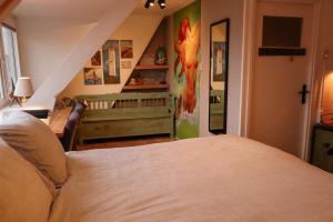 a bedroom with a bed and a baby crib at B&B Zee-en-Zo in Noordwijk