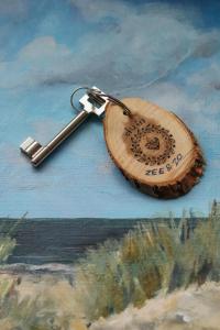 een houten sleutelhanger met een metalen sleutelhanger bij B&B Zee-en-Zo Noordwijk in Noordwijk