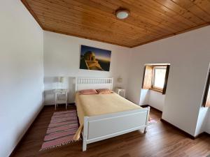 a bedroom with a bed and a wooden ceiling at Casa do Alemao in Porto Judeu