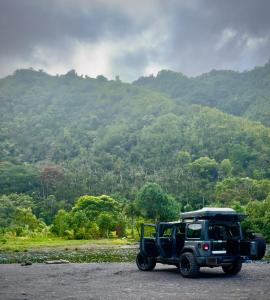 un jeep estacionado frente a una montaña en Embark on a journey through Maui with Aloha Glamp's jeep and rooftop tent allows you to discover diverse campgrounds, unveiling the island's beauty from unique perspectives each day, en Paia