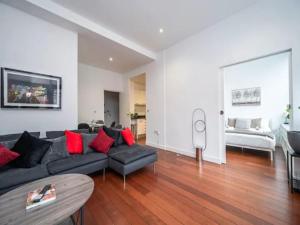 a living room with a black couch and red pillows at Pass the Keys 2 Bed 2 Bath Pentonville Road Angel in London