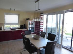 cocina con mesa de madera y sillas y comedor en Villa Lago am Fleesensee, en Göhren-Lebbin 13 fotos más