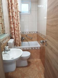 uma casa de banho com um WC, um lavatório e uma banheira em Apartmani Anda em Živogošće