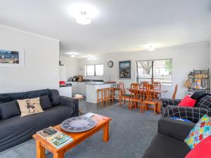 a living room with a couch and a table at Beach Life - Whangamata Holiday Home in Whangamata