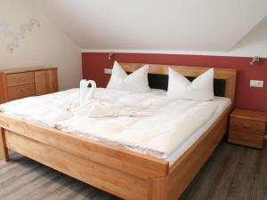 a large bed with white sheets and swans on it at Strandhus Sellin - House 1 in Ostseebad Sellin
