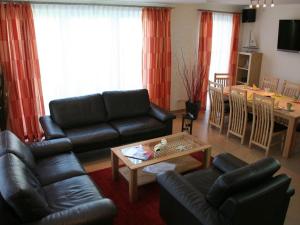 a living room with black leather furniture and a table at Strandhus Sellin - House 1 in Ostseebad Sellin