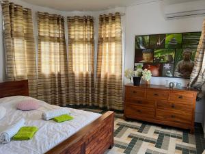 um quarto com uma cama e uma cómoda e cortinas em La Maison Vintage em Petit-Bourg
