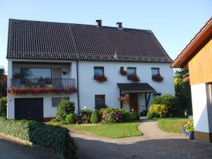 uma casa branca com caixas de flores nas janelas em Ferienwohnung Dorothea em Kulmbach
