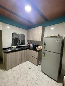 uma cozinha com um frigorífico e um lavatório em Villa Carolina SM em Santa Marta