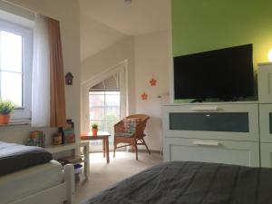 una camera con letto e TV a schermo piatto di Holiday home Heitmann a Nessmersiel