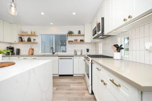 a white kitchen with white cabinets and white appliances at Perfect Renovated and Modern Duplex on Balboa Island in Newport Beach