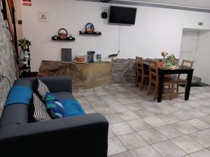 Recanto da Pedra في لينهاريس: غرفة معيشة مع أريكة زرقاء وطاولة