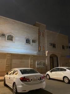 two white cars parked in front of a building at العلم نور in Sīdī Ḩamzah