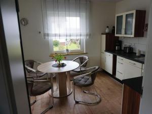 a kitchen with a table and chairs and a window at Elisabeth on the Loreley in Biebernheim