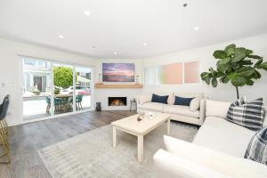 a living room with a white couch and a fireplace at 3 Bedroom Renovated Condo on Balboa Island in Newport Beach