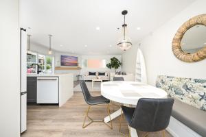 a kitchen and living room with a white table and chairs at 3 Bedroom Renovated Condo on Balboa Island in Newport Beach