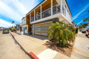 a house with a garage and a palm tree in front of it at 3 Bedroom Renovated Condo on Balboa Island in Newport Beach