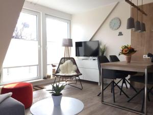een woonkamer met een tafel en een televisie bij Cosy apartment near centre in Langeoog