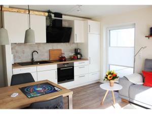 een keuken en een woonkamer met een bank en een tafel bij Cosy apartment near centre in Langeoog