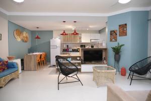 uma sala de estar e cozinha com uma parede azul em Apartamento Praia do Tombo Guarujá 120m do mar no Guarujá