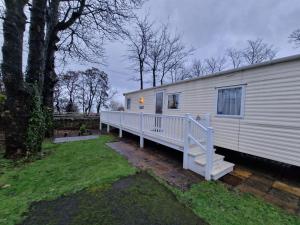 Beautiful Caravan near Edinburgh nr 9 في Port Seton: منزل متنقل مع شرفة ودرج