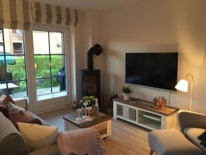 a living room with a flat screen tv on the wall at Holiday apartment SeaSide in Westerbergen
