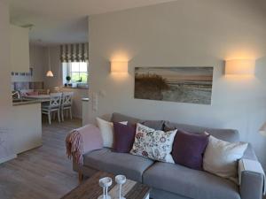 a living room with a couch and a kitchen at Holiday apartment SeaSide in Westerbergen
