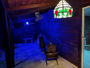 a blue room with a chair and a stained glass window at Sana El Jardin Secreto in Santiago de los Caballeros