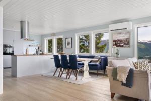 een keuken en een woonkamer met een tafel en stoelen bij House with iconic view in Tromsø