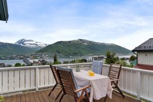een balkon met een tafel en stoelen en bergen bij House with iconic view in Tromsø