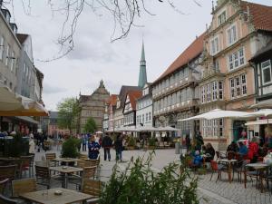 uma rua da cidade com mesas, cadeiras e edifícios em Rauchkate Weibeck em Hessisch Oldendorf