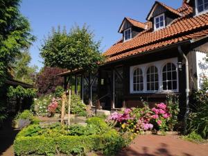 uma casa com um jardim de flores em frente em Rauchkate Weibeck em Hessisch Oldendorf