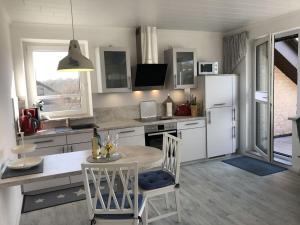 a kitchen with a table and chairs and a refrigerator at Huus Schippe "Stockholm" in Maasholm-Bad