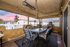 eine Terrasse mit einem Tisch und Stühlen auf dem Balkon in der Unterkunft Spanish Castle By The Sea in Newport Beach in Newport Beach