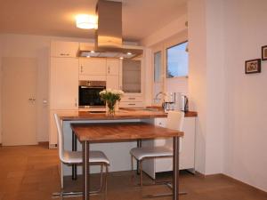 una cucina con tavolo in legno e alcune sedie di Holiday apartment Seega a Timmendorfer Strand