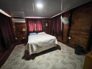 1 dormitorio con 1 cama en una habitación con paredes de madera en Sana El Jardin Secreto, en Santiago de los Caballeros