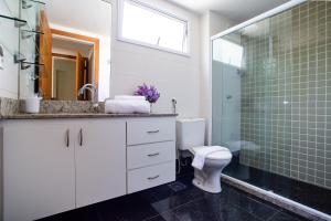 a bathroom with a toilet and a glass shower at Apartamento a 500 m da Praia de Itacoatiara in Niterói