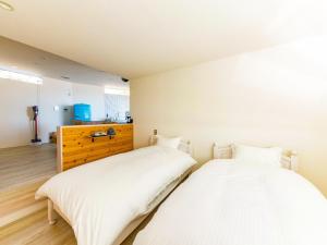 two beds sitting next to each other in a bedroom at URBAN & BEACH - Vacation STAY 74389v in Awaji