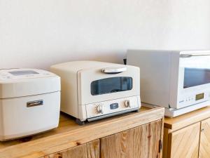 a microwave and a toaster on a wooden cabinet at URBAN & BEACH - Vacation STAY 74389v in Awaji