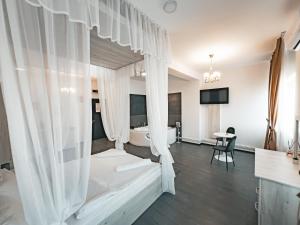 a bedroom with a bed with white curtains at Splendor Boutique Pitesti in Piteşti