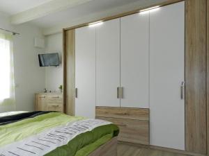 a bedroom with a bed and a large white cabinet at Holiday apartment deck boat in Hoddersdeich