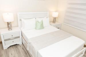 a white bedroom with two beds and two lamps at Garden Oasis 2 Villa With Private Pool in Four Roads